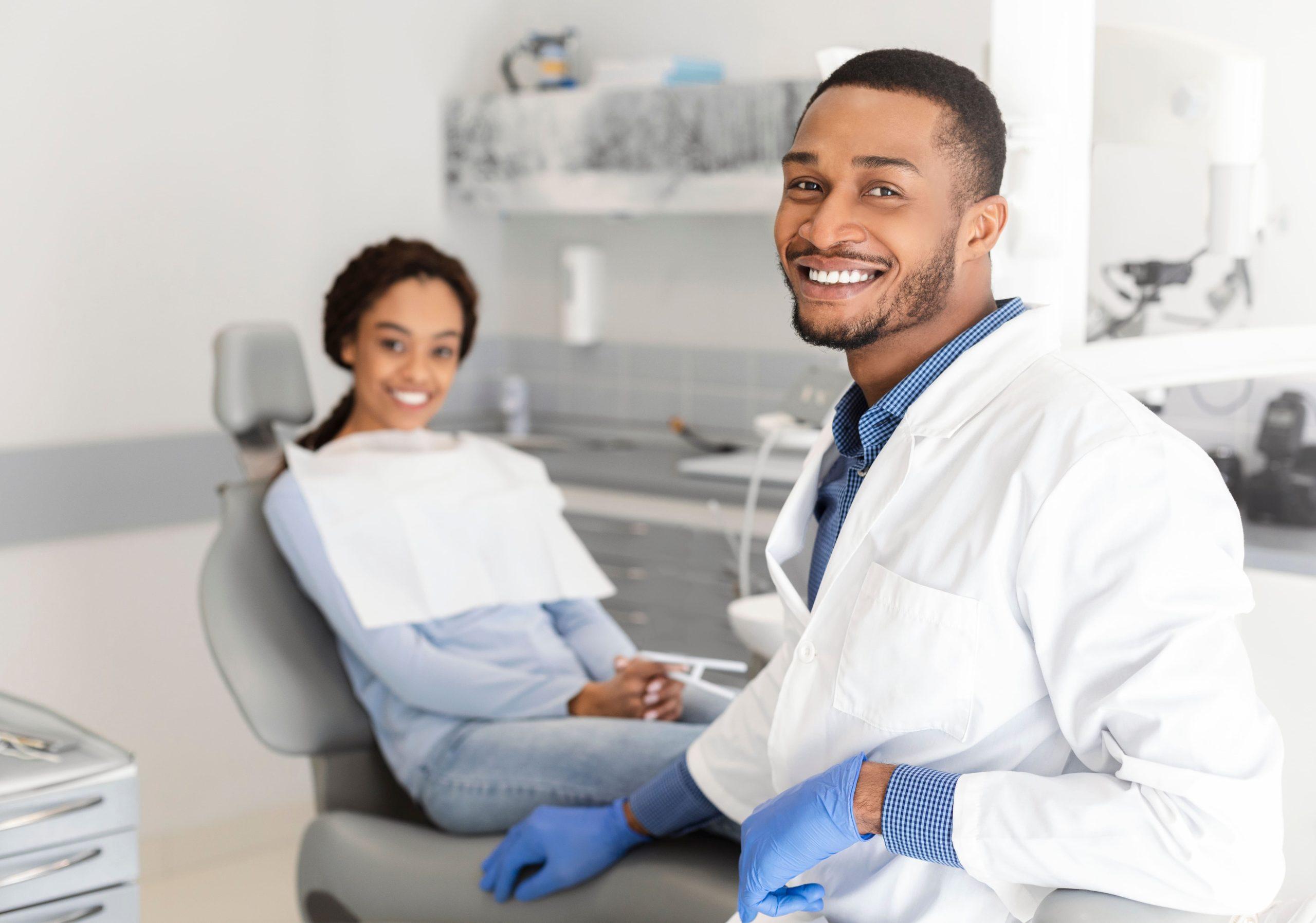 dentist doctor and female patient in chair smiling at camera